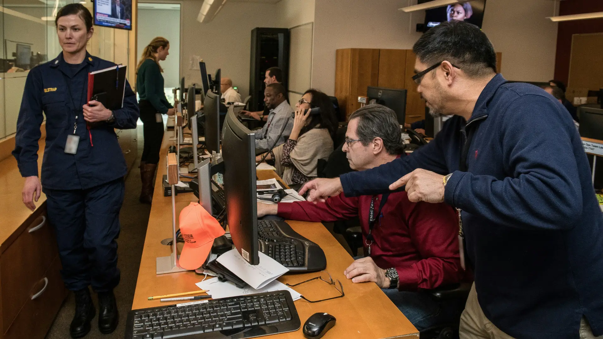 A busy office with several people working at computer stations.